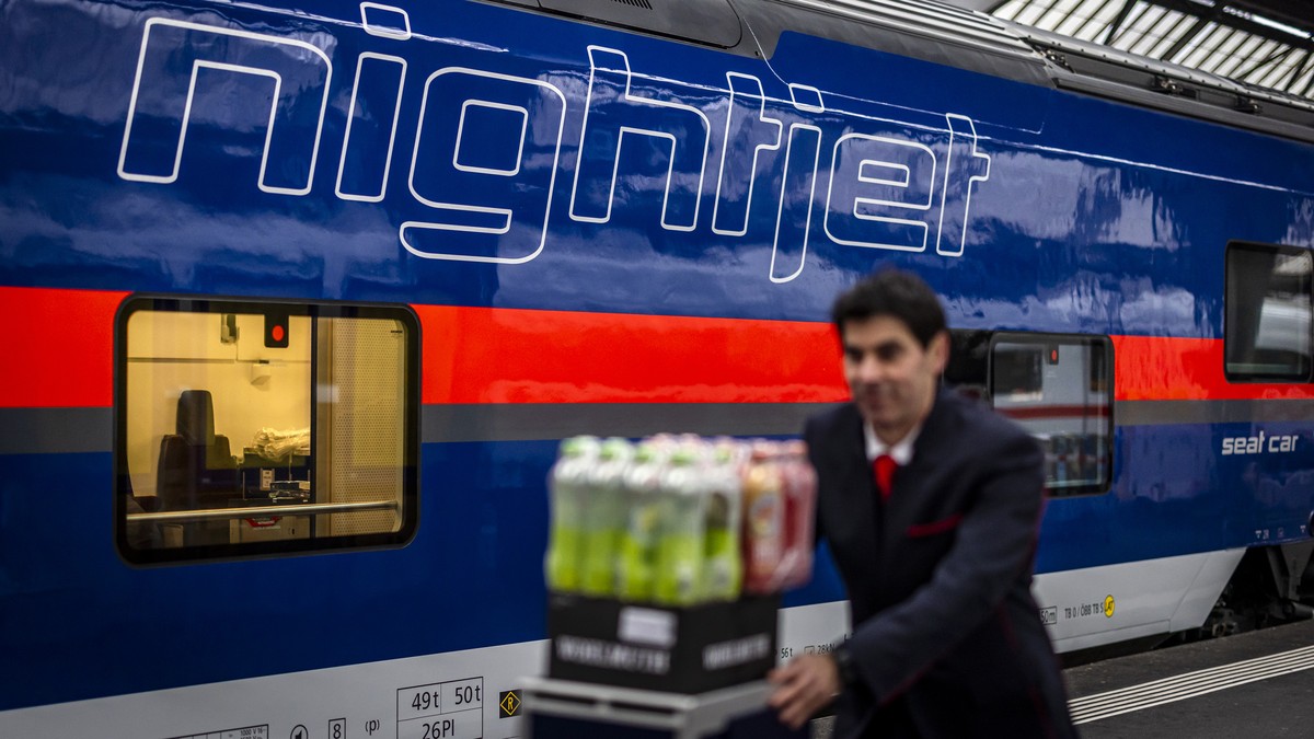 Ein Mitarbeiter geht an einem Nightjet Nachtzug der SBB vorbei, aufgenommen anlaesslich der Taufe des Zuges am Donnerstag, 4. Dezember 2025 am Hauptbahnhof in Zuerich. Ab Dezember 2025 verkehren auf d ...