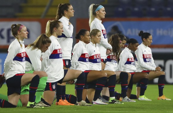 FILE - United States players wear a sweater with the slogan &quot;Black Lives Matter&quot; and most take the knee as the national anthem is played prior to the international friendly women&#039;s socc ...