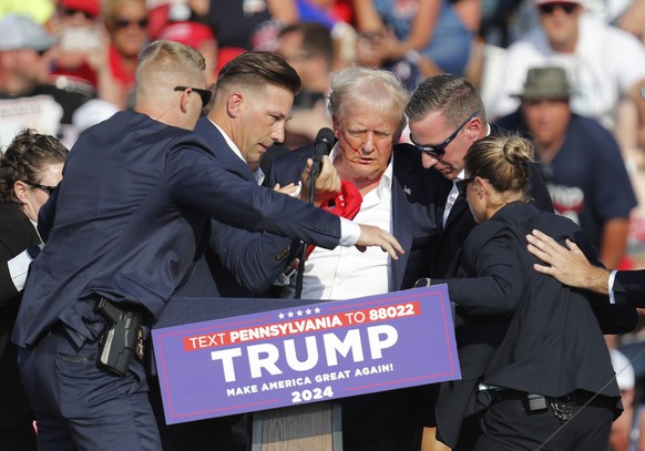 epa11476747 Former US President Donald Trump is rushed off stage by secret service after an incident during a campaign rally at the Butler Farm Show Inc. in Butler, Pennsylvania, USA, 13 July 2024. EP ...