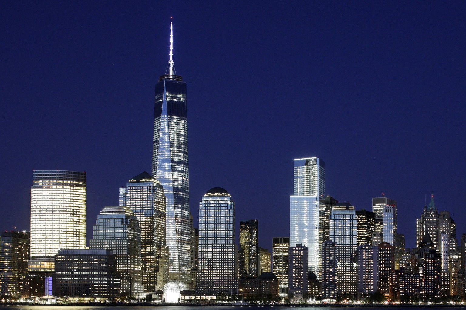 FILE - In this Tuesday, May 6, 2014 file photo, a mostly illuminated One World Trade Center towers over the lower Manhattan skyline in New York. The neon lights of Broadway might not all shine so brig ...
