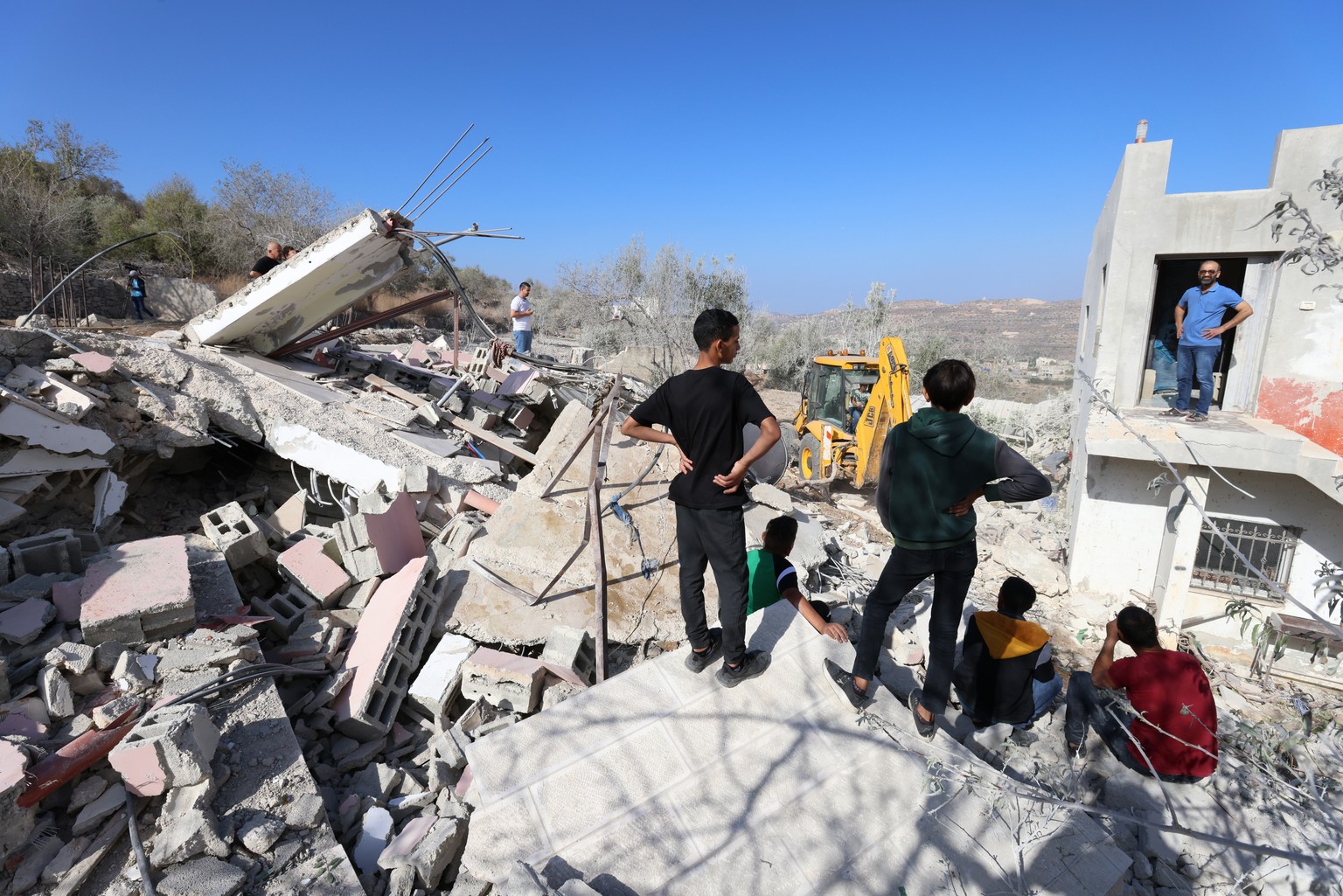 epa10950544 Palestinians gather to inspect the rubble at the site of the demolished family home of a Hamas leader Saleh al-Arouri, in the West Bank village of Arura, northwest of the west bank city of ...