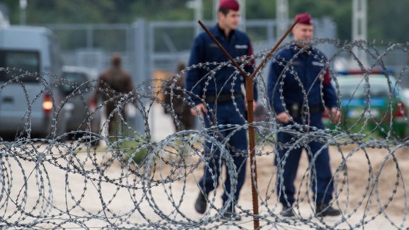 Hungarian policemen patrol along a barbed wire fence in the transit zone at Hungary&#039;s southern border with Serbia is seen near Tompa, 169 kms southeast of Budapest, Hungary, Wednesday, Sept. 21,  ...