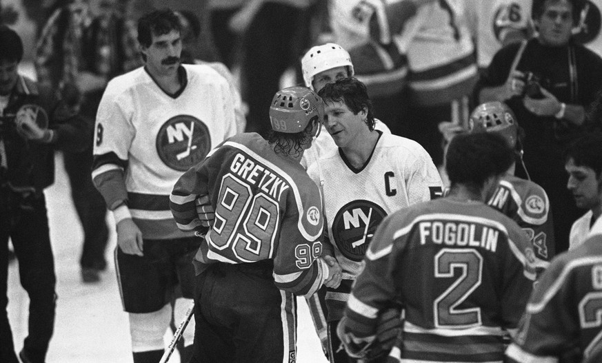 New York Islanders captain Denis Potvin shakes hands with Edmonton Oilers Wayne Gretzky as the two move through the hand shaking ceremonies after the Islanders won their fourth straight NHL Stanley Cu ...