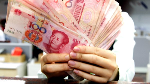 epa04087216 A clerk counts Chinese Yuan - or Reminbi - bills at a post office in Taipei, Taiwan, 19 February 2014. Following Taiwan banks&#039; launch of Renminbi services on 06 February 2013, Taiwan  ...