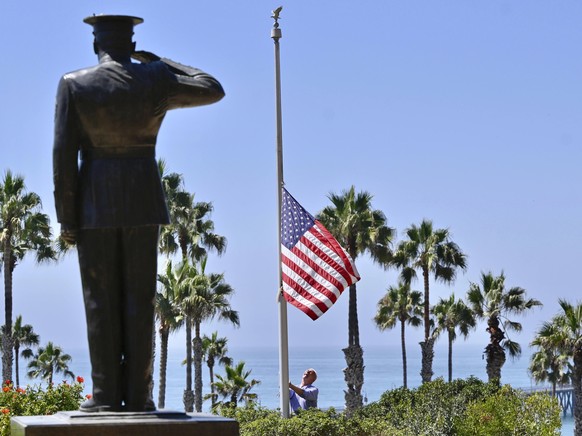 Wayne Eggleston lowers the U.S. flag to half mast at Park Semper Fi in San Clemente, Calif., Friday, Aug. 27, 2021. Eggleston is the former mayor and manages the park that sits on a bluff above the ci ...