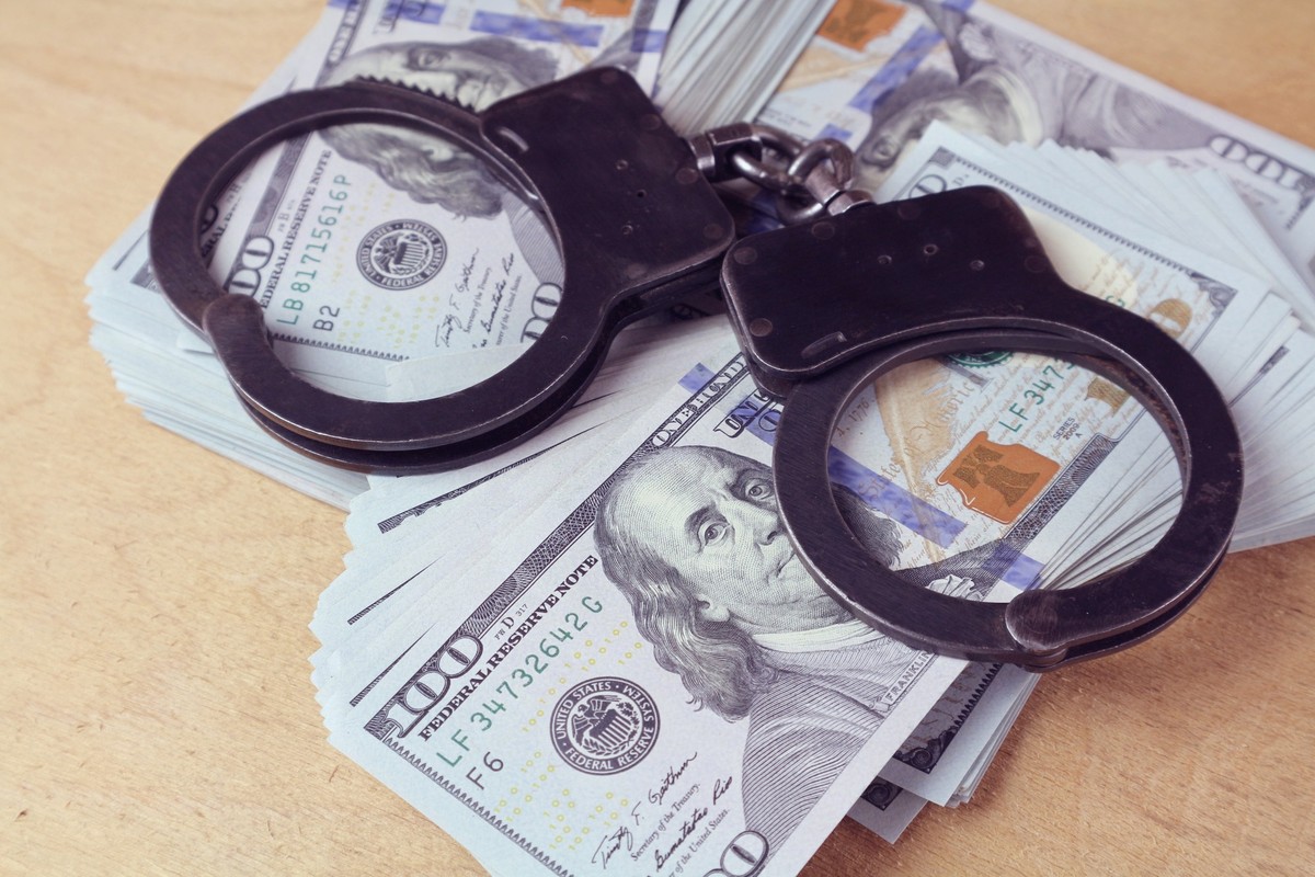 Numéro de la ressource : 2519008495

Les menottes reposent sur des piles de billets de cent dollars sur une table. Photo conceptuelle sur la fraude financière, les escroqueries et les crimes avec de l ...