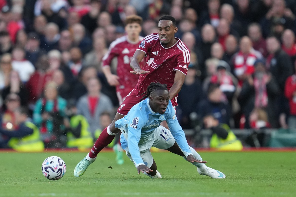 Manchester City's Jeremy Doku, bottom, challenges for the ball with Liverpool's Ryan Gravenberch during the English Premier League soccer match between Liverpool and Manchester City in Liver ...
