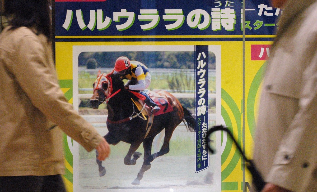 A poster advertising a new pop song praising racing horse "Glorious Spring," or "Haru-urara" in Japanese, attracts passersby at a Tokyo CD store Monday, March 22, 2004. The eight-y ...