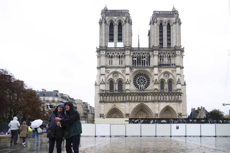 epa11650948 Tourists with raincoats pose for pictures in front of Notre Dame Cathedral in Paris, France, 09 October 2024. Storm Kirk has caused major disruptions in France&#039;s southwest, resulting  ...