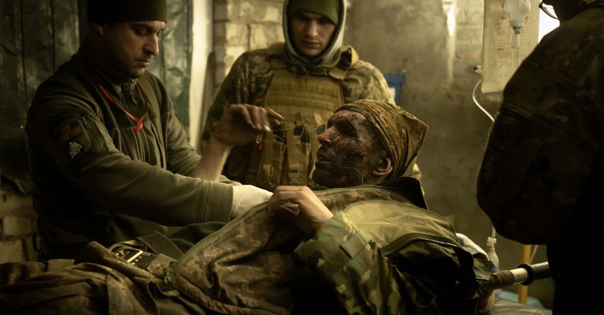 BAKHMUT, UKRAINE - DECEMBER 04: Military medics work on a member of the Ukrainian military suffering from head and leg injuries caused by a mine, in a frontline field hospital on December 04, 2022 out ...
