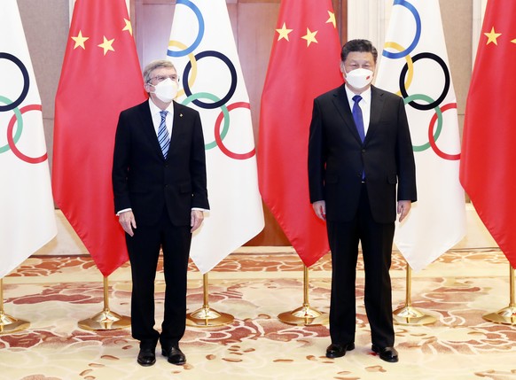 In this photo released by China's Xinhua News Agency, International Olympic Committee (IOC) President Thomas Bach, left, and Chinese President Xi Jinping meet at the Diaoyutai State Guesthouse in Beij ...