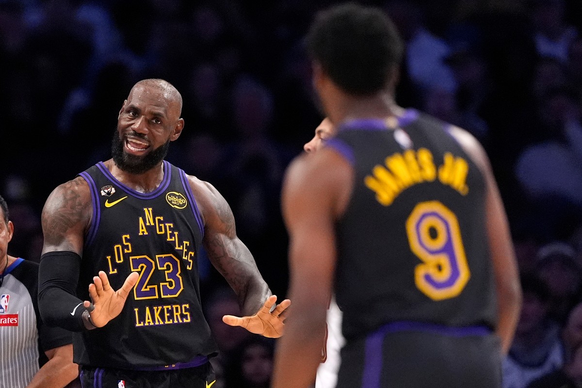 Los Angeles Lakers forward LeBron James, left, talks to guard Bronny James during the first half of an NBA basketball game against the Cleveland Cavaliers, Tuesday, March 31, 2026, in Los Angeles. (AP ...