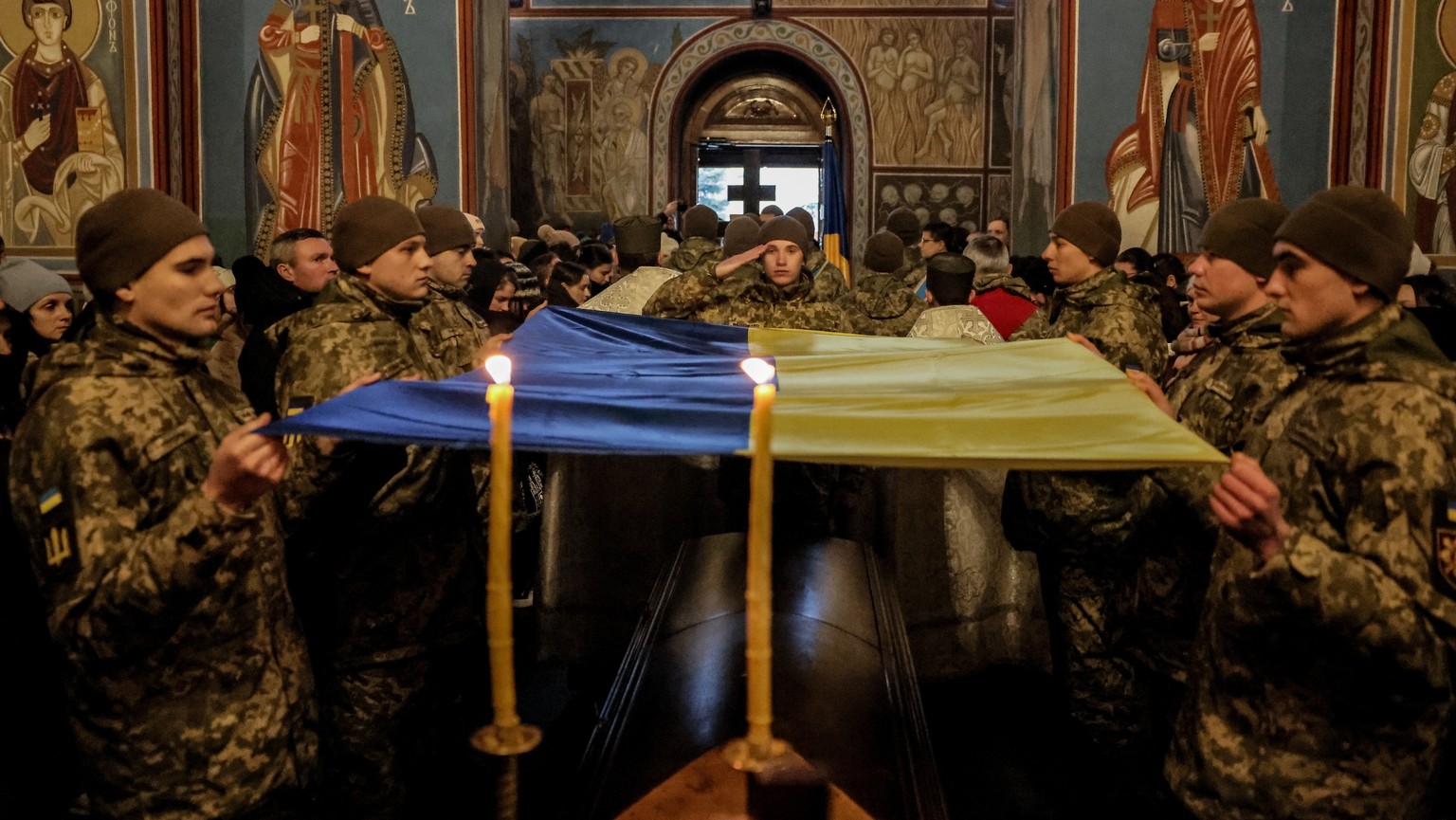 epa11069617 A guard of honor holds the national flag at the funeral ceremony for Ukrainian serviceman Maksym Kryvtsov at St Michael&#039;s Golden-domed monastery in Kyiv, Ukraine 11 January 2024. Maks ...