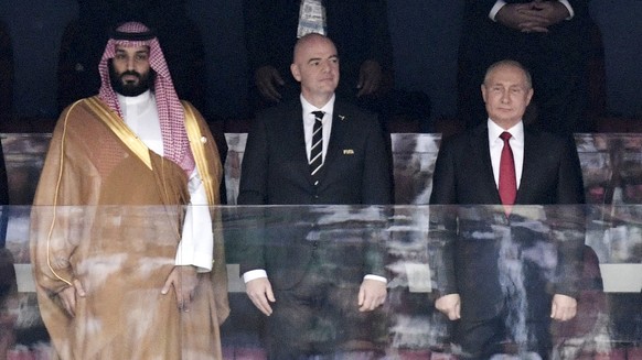 FILE - Crown Prince Mohammed bin Salman of Saudi Arabia, left, FIFA President Gianni Infantino, center, and Russian President Vladimir Putin stand for the national anthem ahead of the match between Russia and Sau...