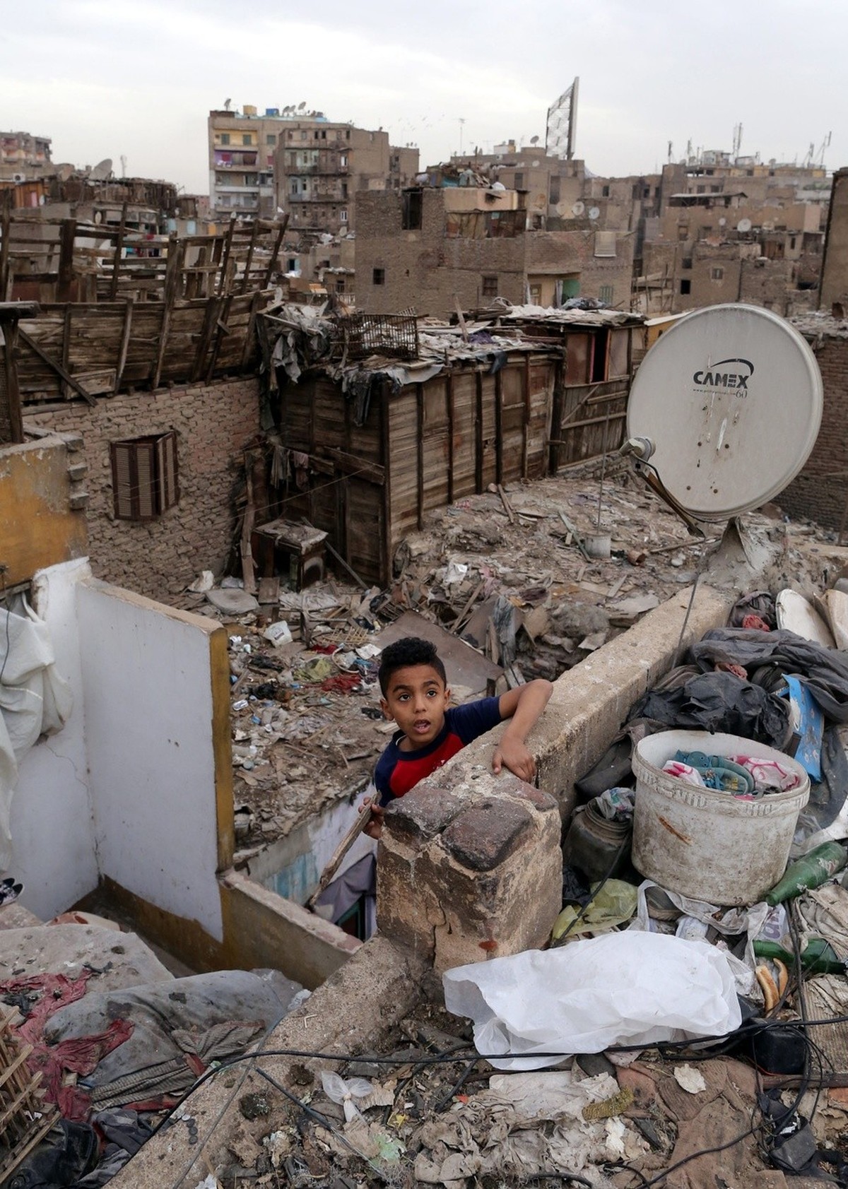 epa04678846 An Egyptian boy plays on the roof of a home at the Bulaq slum in Cairo, Egypt, 25 March 2015. According to estimates, about 16 million Egyptians live in slum neighborhoods lacking basic fa ...