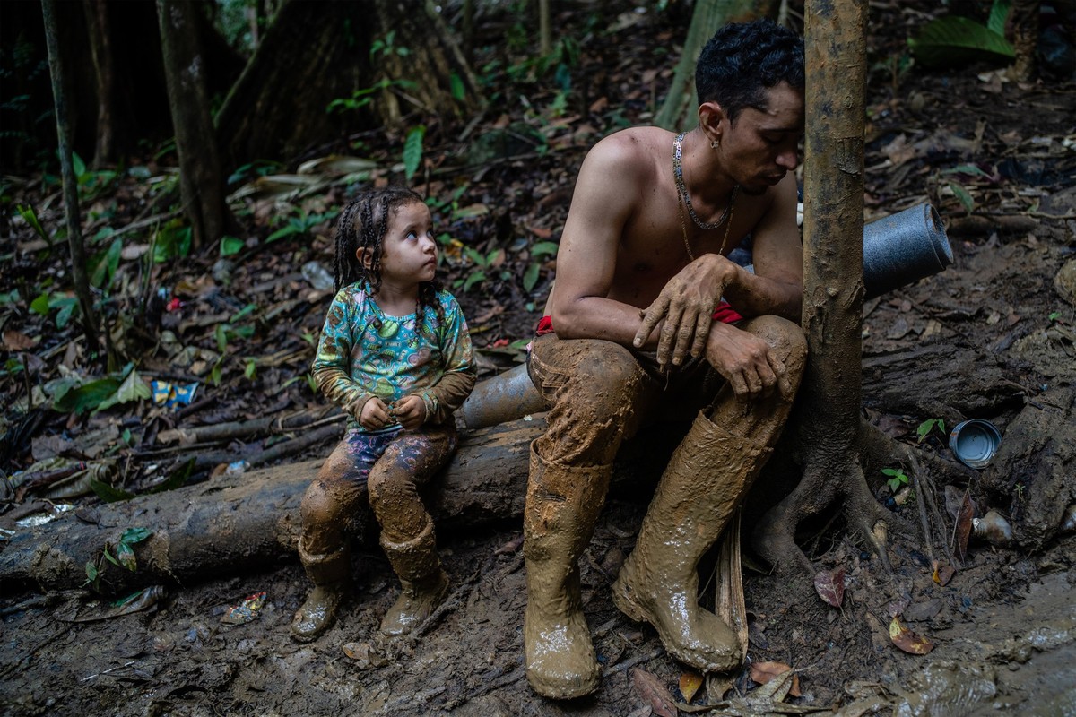 A man resting exhausted while climbing a hill at the Darien Gap, between Colombia and Panama, September 23, 2022. (Federico Rios Escobar)