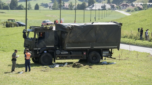 Personen untersuchen die Unfallstelle eines Ladstwagen der Armee, am Montag, 16. Juli 2018, in Linden bei Oberdiessbach. Aus noch unbekannten Gruenden ueberschlug sich das Fahrzeug der Schweizer Armee ...