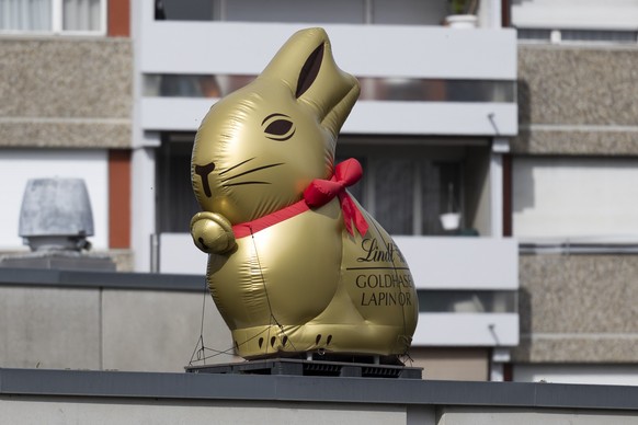 Ein aufblasbarer goldfarbiger Osterhase wirbt vor einem Wohnblock fuer den Lindt Schokolade Goldhasen, am Ostersonntag, 31. Maerz 2024 in Ostermundigen. (KEYSTONE/Peter Klaunzer)
