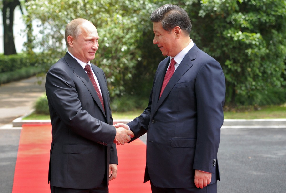 Russia's President Vladimir Putin, left, and China's President Xi Jinping shake hands during a welcome ceremony at the Xijiao State Guesthouse ahead of the fourth Conference on Interaction a ...