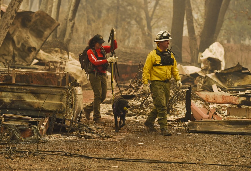 Butte County Search and Rescue worker Noelle Francis, left, and search dog Spinner look through the ashes for survivors and remains after a wildfire ravaged the area, at Skyway Villa Mobile Home and R ...