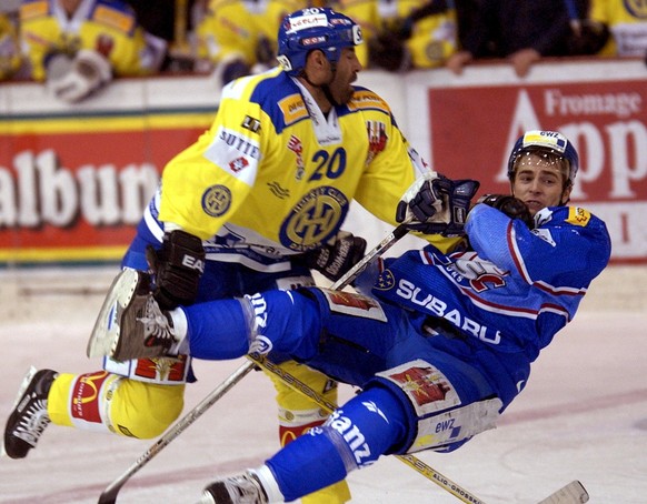 Der Davoser Verteidiger Andrea Haeller, links, legt den Zuercher Raeto Raffainer quer in die Luft, im NLA Eishockey Meisterschaftsspiel zwischen dem HC Davos und den ZSC Lions am Freitag, 30. Januar 2 ...