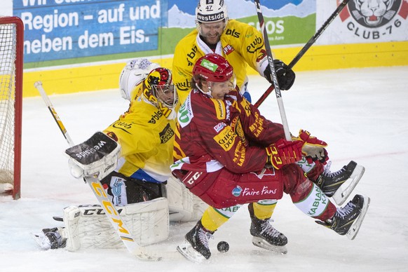 Tigers, Loic In-Albon, Mitte rechts, kaempft um den Puck, gegen Berns Goalie, Pascal Caminada, und Andrew MacDonald, Mitte, waehrend dem Meisterschaftsspiel der National League, zwischen den SCL Tiger ...