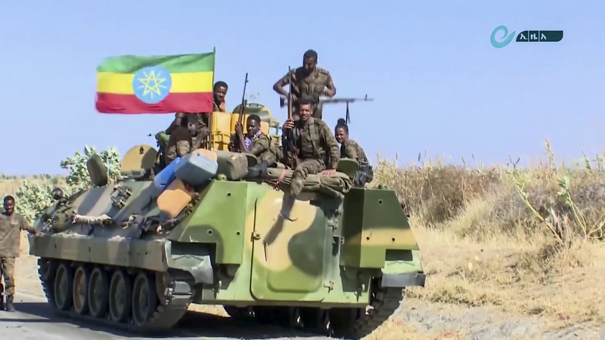 This image made from undated video released by the state-owned Ethiopian News Agency on Monday, Nov. 16, 2020 shows Ethiopian military sitting on an armored personnel carrier next to a national flag,  ...