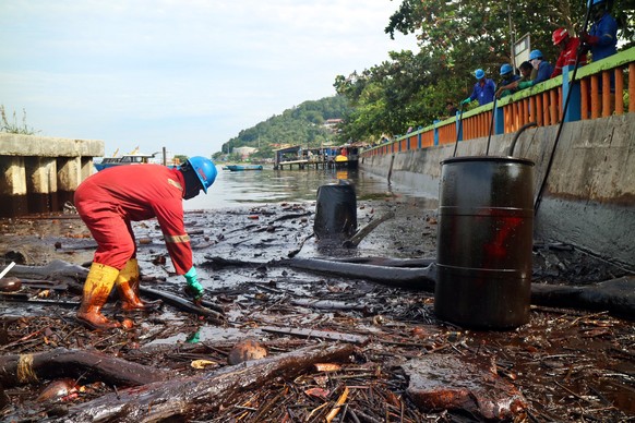 epa06644493 Indonesian workers from state owned oil company, Pertamina, clean up oil polluting Melawai beach from an oil spill in the water off Balipapan, East Kalimantan, Indonesia, 04 April 2018. Th ...