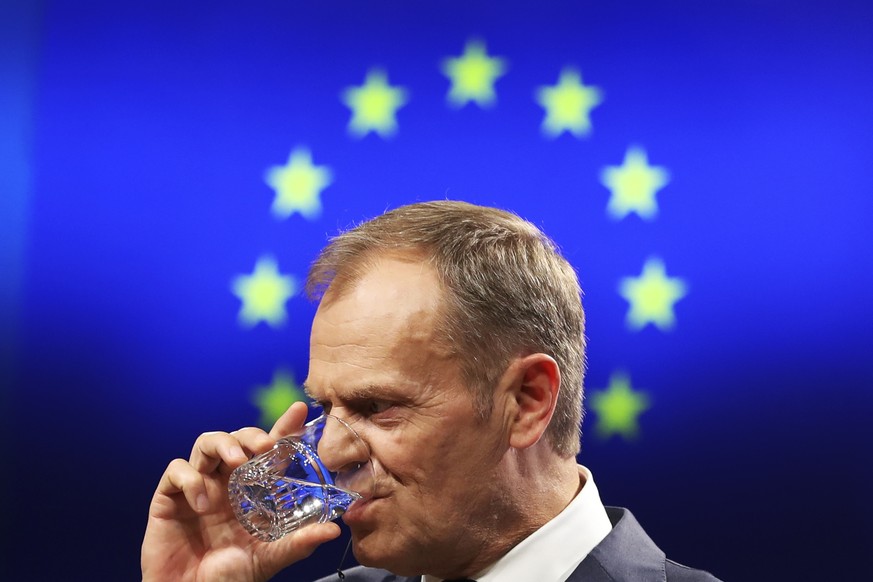 European Council President Donald Tusk drinks during a joint news conference with China&#039;s Premier Li Keqiang and European Commission President Jean-Claude Juncker during an EU-China summit at the ...