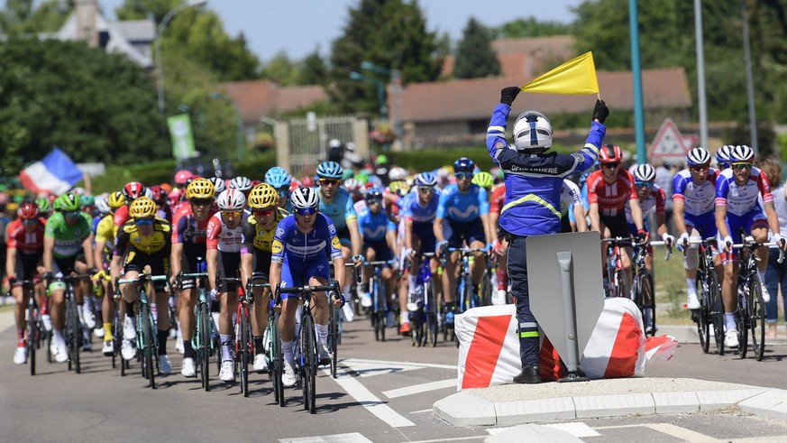 Tour de France 2019 - Stage 04 NANCY, FRANCE - JULY 9 : The peloton passing a policeman with a yellow security flag during stage 4 of the 106th edition of the 2019 Tour de France cycling race, a stage ...
