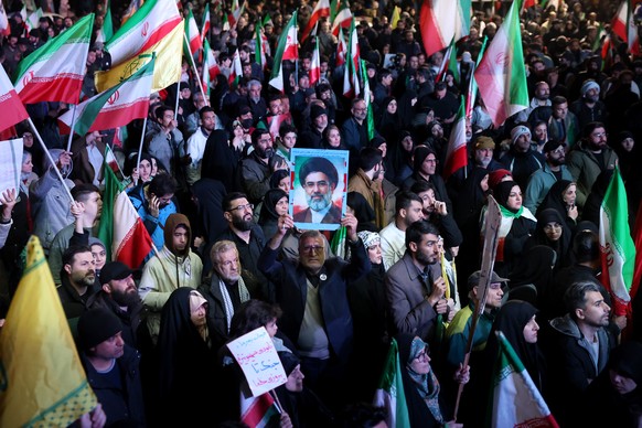 epa12874356 Iranians wave flags during a demonstration following the announcement of a two-week ceasefire at Enghelab Square in Tehran, Iran, 08 April 2026. Iran and the USA agreed to the two-week tru ...