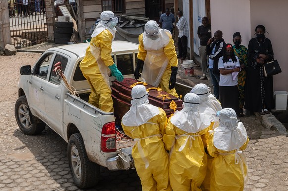 epa12987167 Health workers wearing full personal protective equipment (PPE) prepare to transport the body of an Ebola victim for a safe burial at Sofepadi Hospital in Bunia, Ituri province, Democratic ...