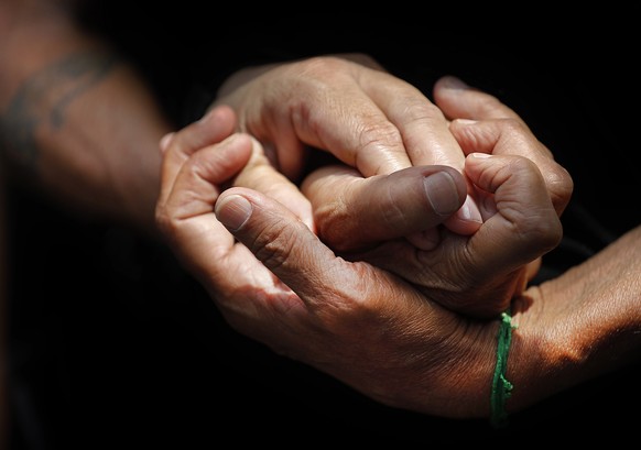 Relatives of people who are missing after the explosion Tuesday that hit the seaport of Beirut, hold hands as they wait outside the port to receive any information from the rescue teams, in Beirut, Le ...