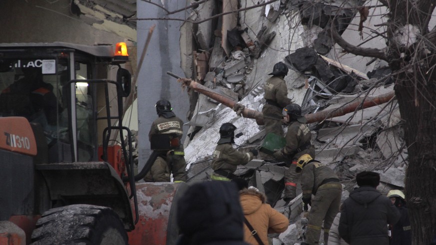 epa07254871 Russian rescue workers remove debris after a gas explosion in an apartment building in the city of Magnitogorsk, Chelyabinsk region, Russia, 31 December 2018. The explosion at a Magnitogor ...