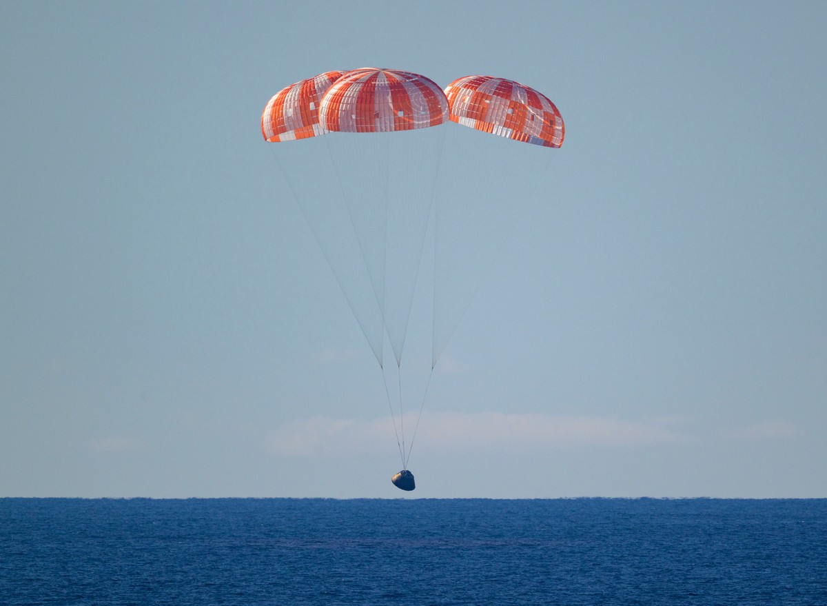 In this photo provided by NASA, the Orion spacecraft with Artemis II crewmembers aboard approaches the surface of the Pacific Ocean for splashdown off the coast of California, Friday, April 10, 2026.  ...