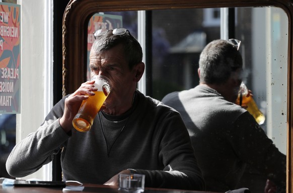 A man drinks a pint of beer in the Black Lion pub in Hammersmith in London, Monday, May 17, 2021. Drinks were raised in toasts and reunited friends hugged each other as thousands of U.K. pubs and rest ...