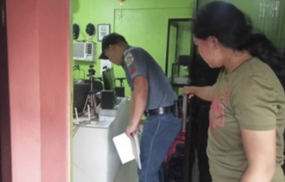 In this handout photo provided by the Calamba Municipal Police Station, a police officer on the left checks the area where a radio presenter was fatally shot by a man at his home station in Calamba to…