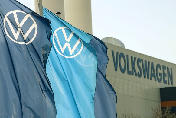FILE - In this file photo dated Thursday, April 23, 2020, flags wave in front of a factory building during the production restart of the plant of the German manufacturer Volkswagen AG (VW) in Zwickau, ...