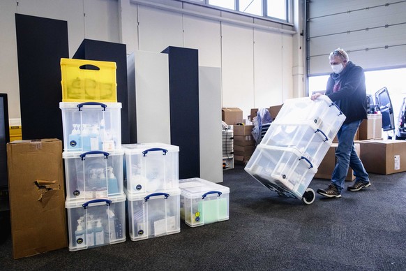 epa08911003 An employee brings equipment to administer the vaccine, during the set up of a vaccination center at the Expo Houten, The Netherlands, 30 December 2020. The location is one of the three lo ...