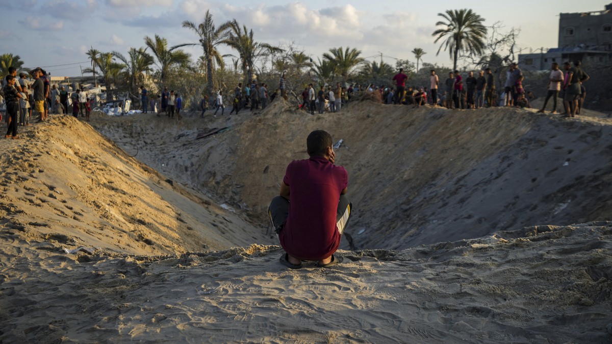 Palestinians look at the destruction after an Israeli airstrike on a crowded tent camp housing Palestinians displaced by the war in Muwasi, Gaza Strip, Tuesday, Sept. 10, 2024. An Israeli strike kille ...