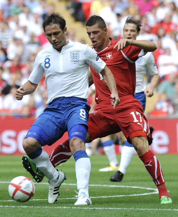 England's midfielder Frank Lampard, left, fights for the ball against Swiss forward Granit Xhaka, right, during a UEFA European Championship Euro 2012 qualifying group match between England and S ...