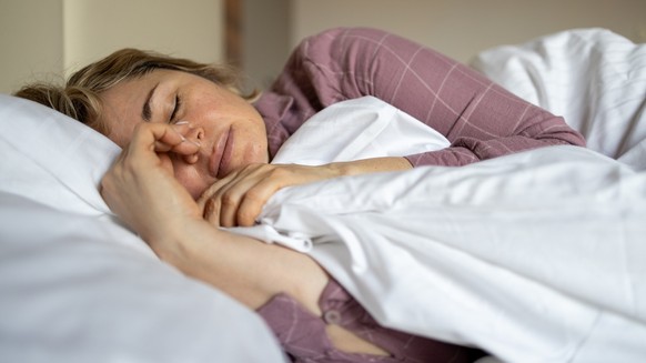 Mature woman in depression lying in bed covered with blanket. Melancholy mood, mental health, menopause Life problem. Insomnia and psychological issues.