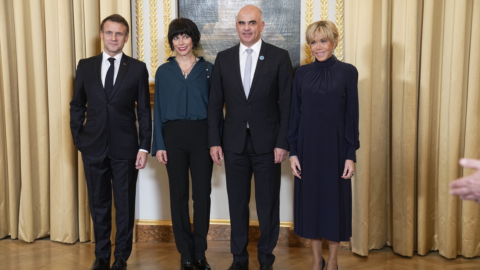 epa10967450 French President Emmanuel Macron (L), and his wife Brigitte Macron (R), greet Switzerland President Alain Berset (C-R) and his wife Muriel Zeender Berset (C-L) as they attend a dinner ahea ...