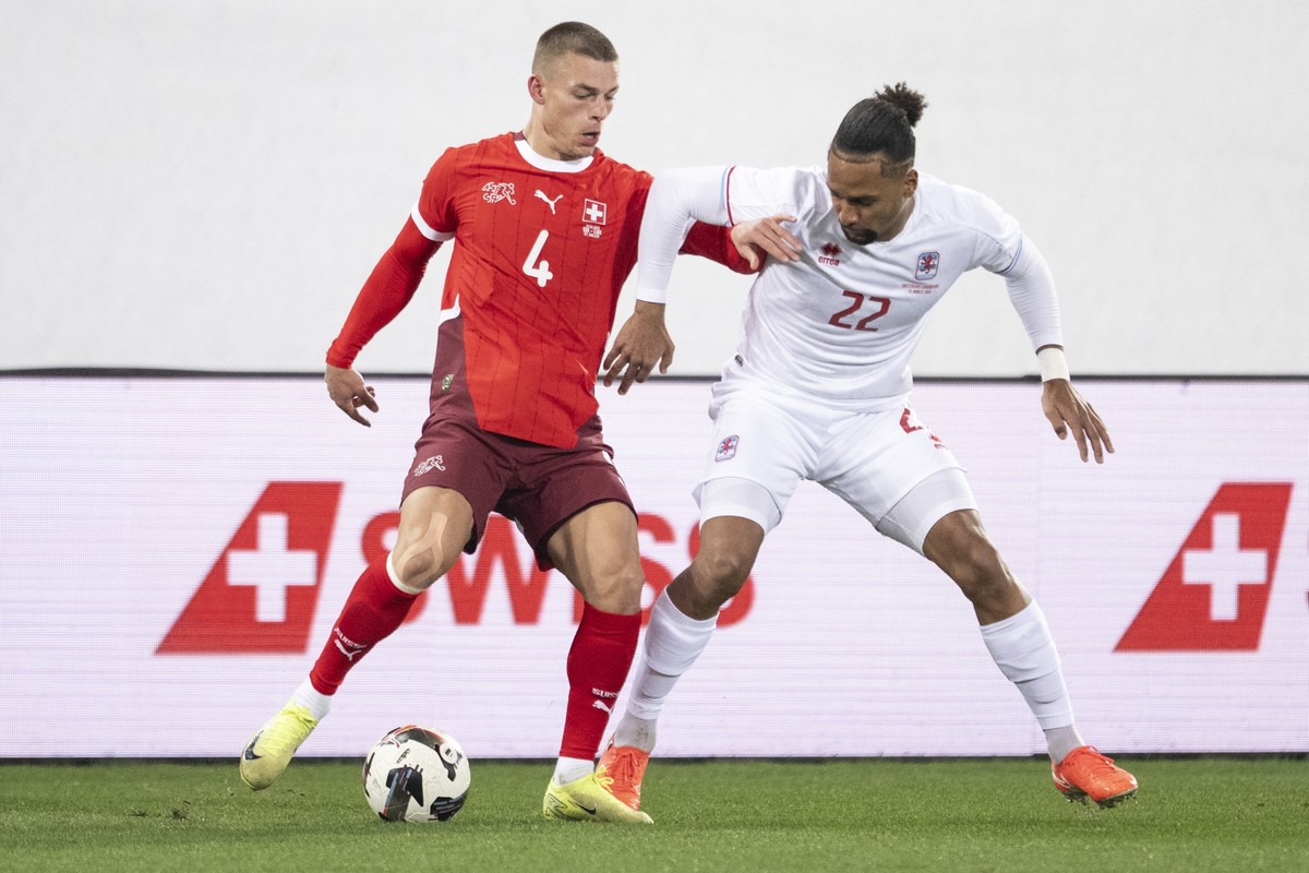 epa11988242 Switzerland's Miro Muheim (left) fights for the ball against Luxembourg's Marvin Martins (right) during a friendly soccer match between Switzerland and Luxembourg at the Kybunpar ...