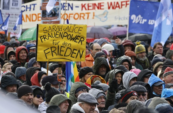 epa10490237 People attends the demonstration &#039;Uprising for Peace&#039; in front of the Brandenburg gate in Berlin, Germany, 25 February 2023. Words read: &#039;Sarah + Alice Women&#039;s Power fo ...