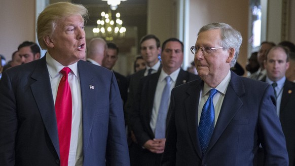 epa05625949 US President elect Donald Trump (C), with his wife Melania Trump (L), and Senate Majority Leader Mitch McConnell (R), responds to a question from the news media after a meeting in the Majo ...