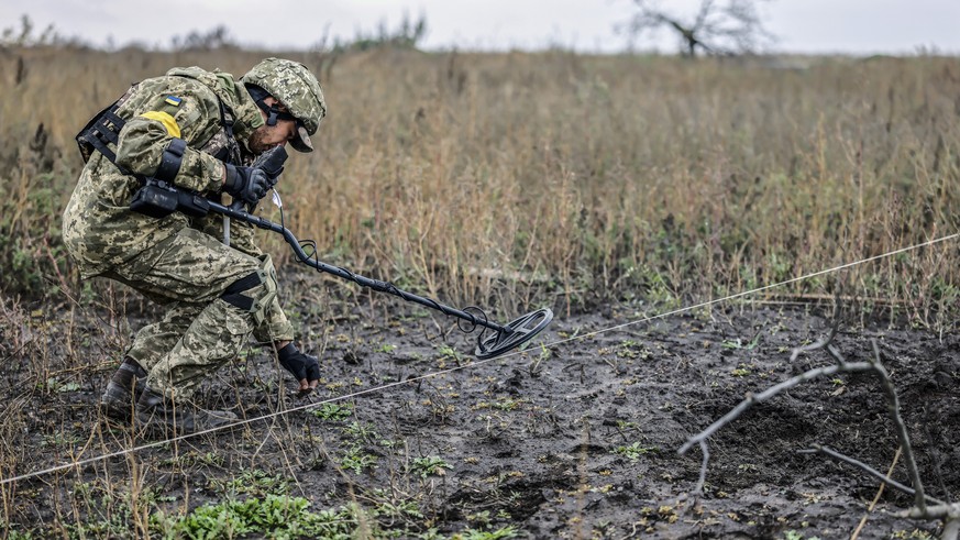 epa10264736 A Ukrainian soldier searches for explosives at a recapture area in the north of Kherson, Ukraine, 25 October 2022. Russian troops on 24 February entered Ukrainian territory, starting a con ...