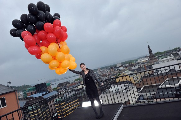 epa02171177 German singer Lena Meyer-Landrut holds some balloons with the colors of the German flag on the roof of a building in the Norwegian capital Oslo, Norway, 24 May 2010. Lena will represent Ge ...