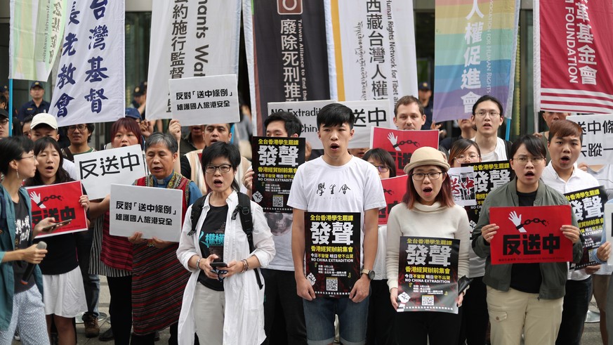 epa07642560 Protestors shout slogans and display placards during a protest to support Hong Kong protesters who are against the amendments to an extradition bill, in Taipei, Taiwan, 12 June 2019. The b ...