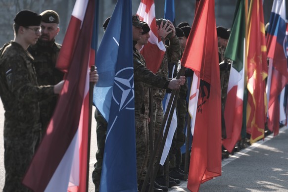 epa12811119 Soldiers hold NATO and national flags during the visit of the Czech president, Petr Pavel (not pictured), to the Adazi Military Base, Latvia, 11 March 2026. Czech President Petr Pavel visi ...